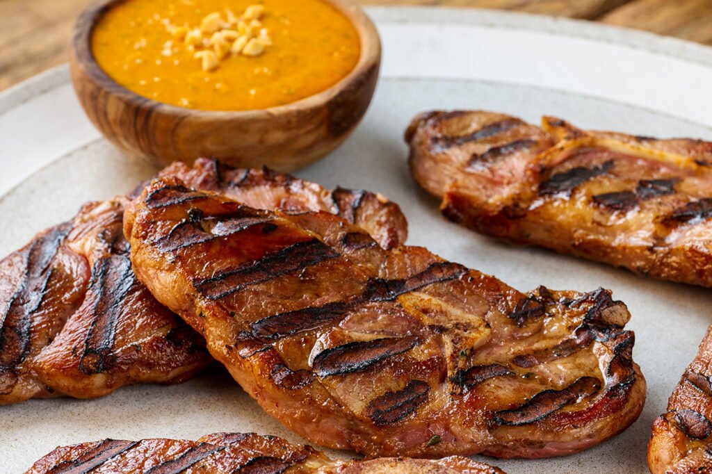 plato de Chuletas a la parrilla con salsa de mani